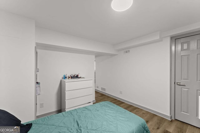 bedroom with dark wood-type flooring