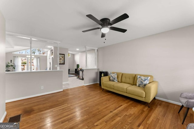 living room with ceiling fan and light wood-type flooring