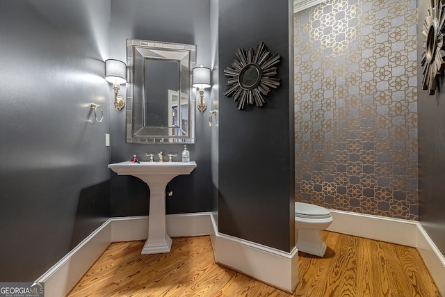 bathroom with hardwood / wood-style floors and toilet