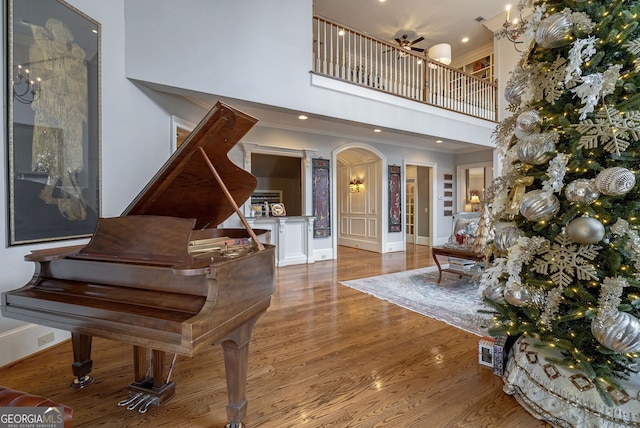 interior space with hardwood / wood-style floors, ceiling fan, and a high ceiling