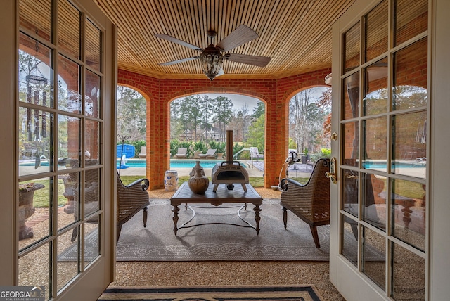 sunroom with french doors, ceiling fan, and wood ceiling