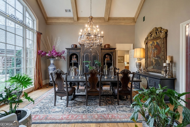 dining space with hardwood / wood-style floors, beamed ceiling, and a notable chandelier