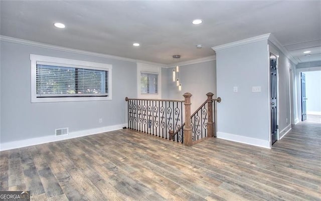 spare room featuring dark wood-type flooring and crown molding