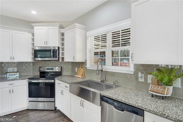 kitchen featuring appliances with stainless steel finishes, backsplash, sink, white cabinets, and dark hardwood / wood-style floors