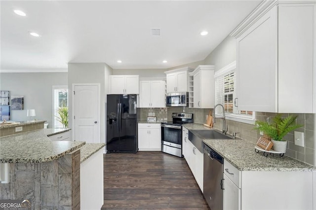 kitchen with white cabinetry, sink, stainless steel appliances, and light stone counters