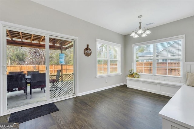 dining area with dark hardwood / wood-style flooring and a chandelier