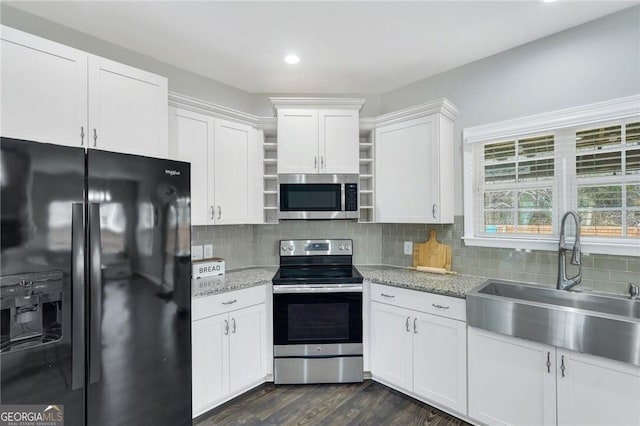 kitchen with decorative backsplash, appliances with stainless steel finishes, white cabinetry, and sink