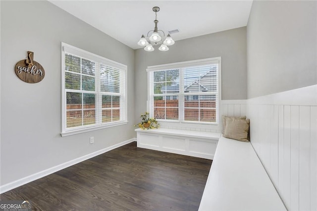 interior space featuring plenty of natural light, dark wood-type flooring, and a chandelier