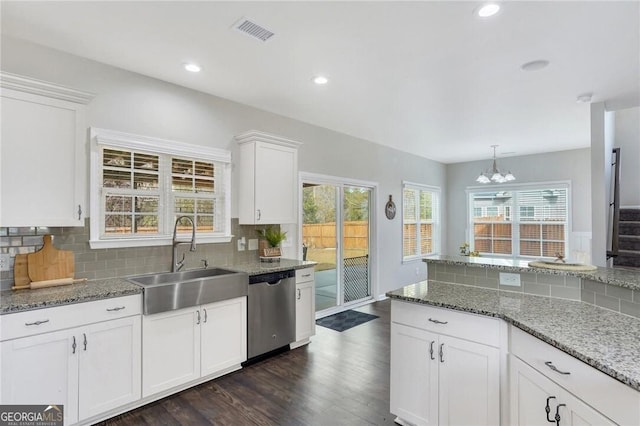 kitchen with sink, stainless steel dishwasher, a notable chandelier, decorative backsplash, and white cabinets