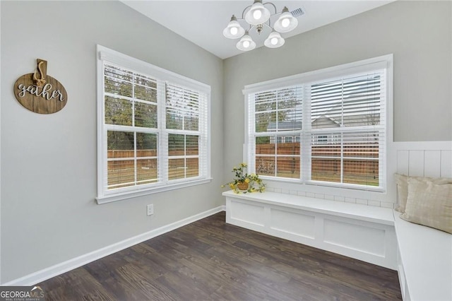 unfurnished dining area with a chandelier and dark hardwood / wood-style flooring