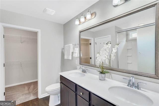 bathroom featuring hardwood / wood-style floors, vanity, toilet, and a shower with shower door