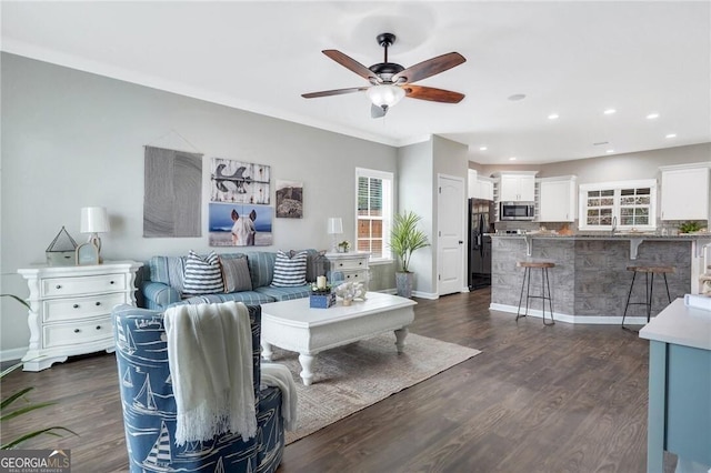 living room featuring ceiling fan, dark hardwood / wood-style flooring, and crown molding