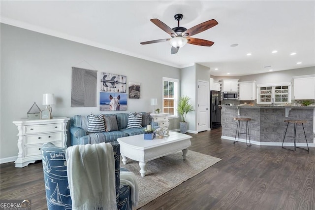 living room featuring ceiling fan, crown molding, and dark wood-type flooring