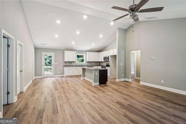 kitchen with ceiling fan, white cabinets, high vaulted ceiling, a kitchen island, and light hardwood / wood-style floors