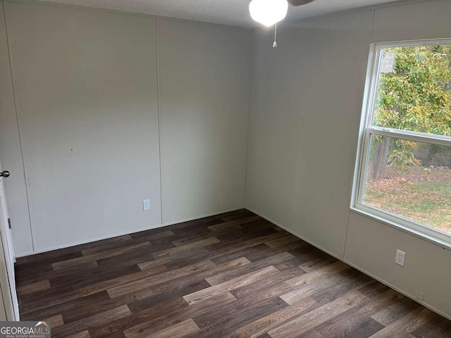 spare room with dark hardwood / wood-style flooring and ceiling fan