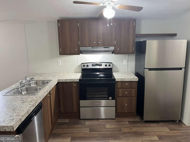 kitchen featuring sink, ceiling fan, a textured ceiling, appliances with stainless steel finishes, and dark hardwood / wood-style flooring