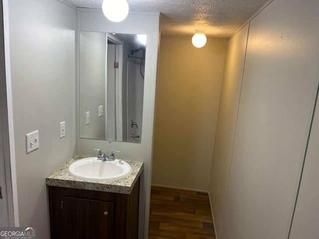 bathroom with vanity, wood-type flooring, and a textured ceiling