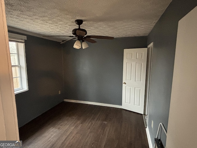 unfurnished room with ceiling fan, dark hardwood / wood-style floors, and a textured ceiling