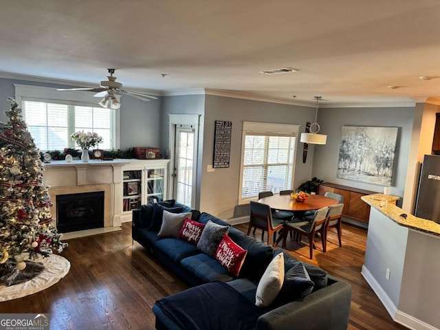 living room featuring dark hardwood / wood-style floors, ceiling fan, and ornamental molding