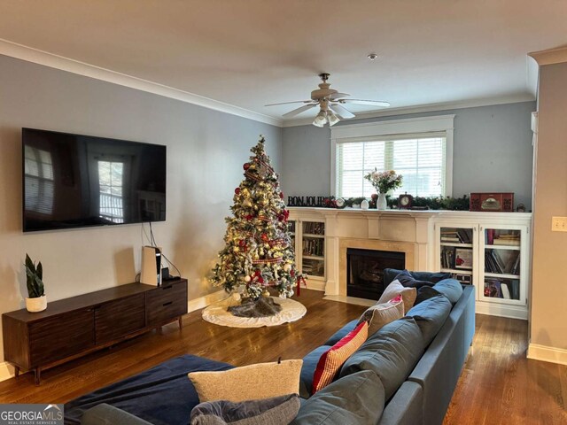 living room featuring hardwood / wood-style floors, ceiling fan, and crown molding