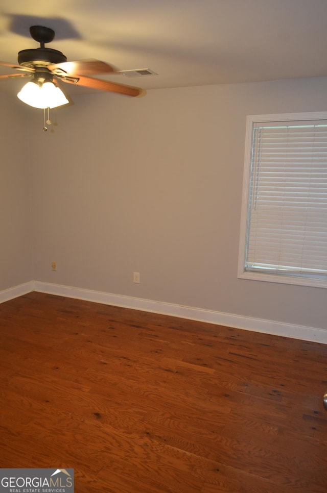 spare room featuring ceiling fan and dark hardwood / wood-style flooring