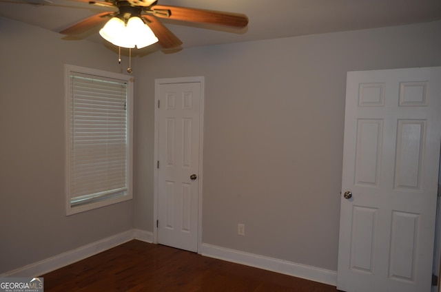 empty room featuring ceiling fan and dark hardwood / wood-style flooring