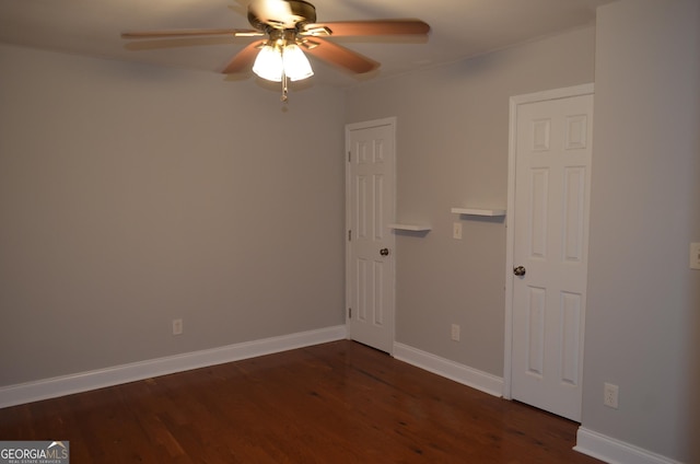 spare room with ceiling fan and dark wood-type flooring