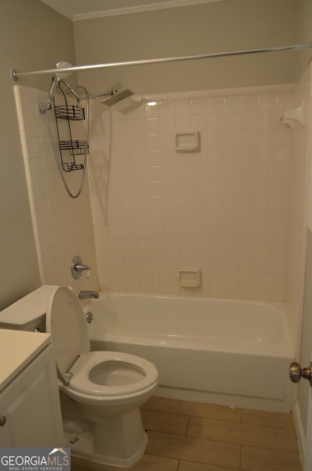 full bathroom featuring vanity, tiled shower / bath combo, toilet, and crown molding