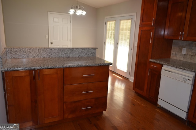 kitchen with dishwasher, hanging light fixtures, dark hardwood / wood-style floors, backsplash, and a chandelier