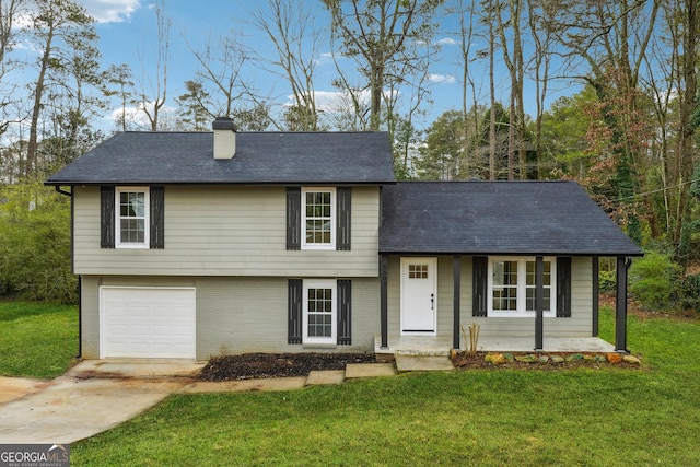 tri-level home with a garage, a front yard, and covered porch