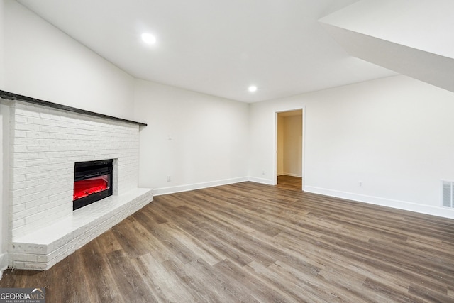 unfurnished living room featuring a fireplace and wood-type flooring