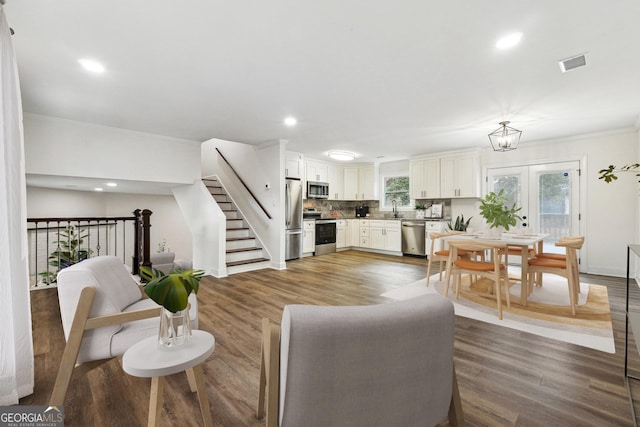 living room featuring sink, ornamental molding, dark hardwood / wood-style floors, and french doors