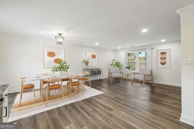 dining room with crown molding, dark wood-type flooring, and an inviting chandelier