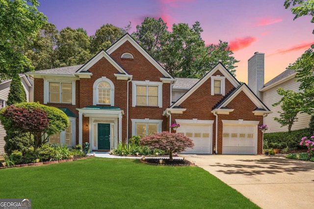 view of front of house featuring a garage and a lawn