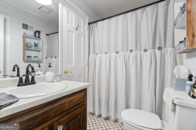 bathroom with vanity, ornamental molding, and toilet