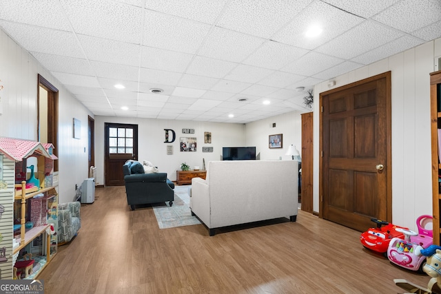 living room with wood-type flooring and a paneled ceiling