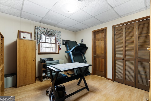 office area with a paneled ceiling and light hardwood / wood-style floors