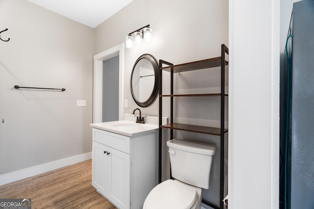 bathroom featuring wood-type flooring, vanity, and toilet