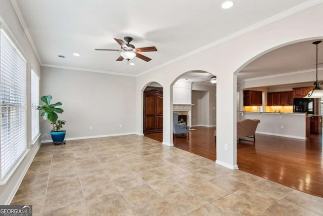 unfurnished room with ceiling fan, light tile patterned flooring, and ornamental molding