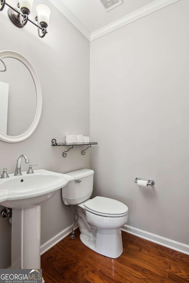 bathroom featuring crown molding, sink, wood-type flooring, and toilet