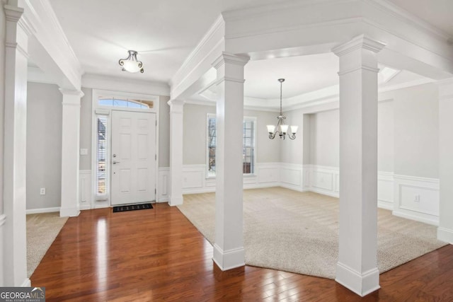 carpeted foyer with crown molding and a notable chandelier