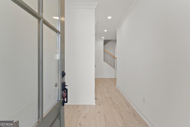 interior space with light wood-type flooring and crown molding