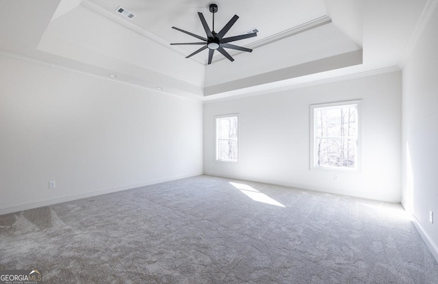 carpeted spare room with a tray ceiling, ornamental molding, and ceiling fan