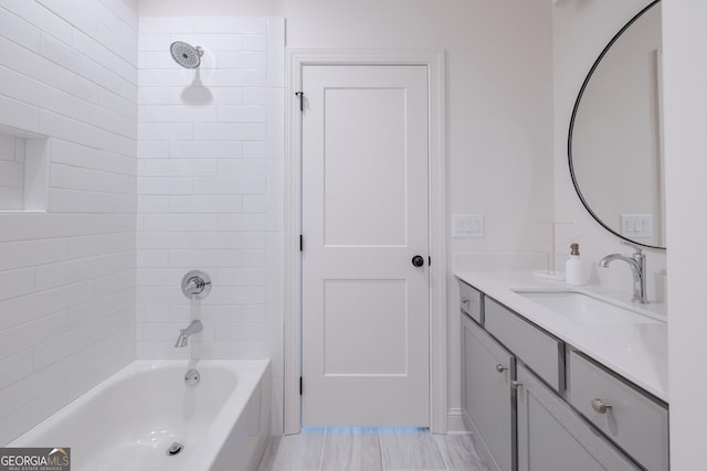 bathroom featuring tiled shower / bath combo and vanity