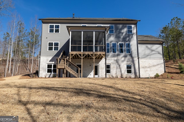 rear view of property featuring a lawn and a sunroom