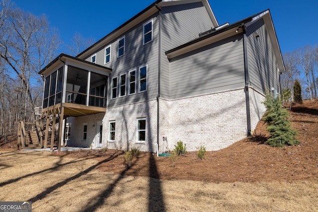 back of property featuring ceiling fan and a sunroom