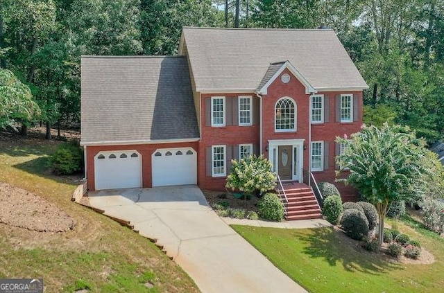 colonial home featuring a garage and a front lawn