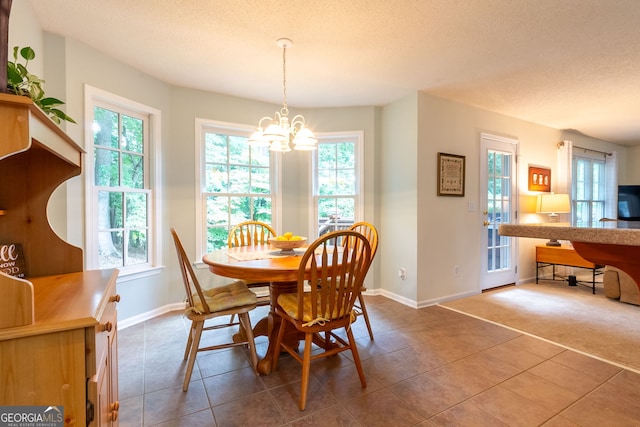 dining room featuring a textured ceiling, an inviting chandelier, and tile patterned flooring