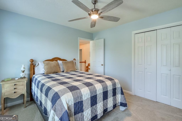 bedroom with ceiling fan, a closet, and light carpet