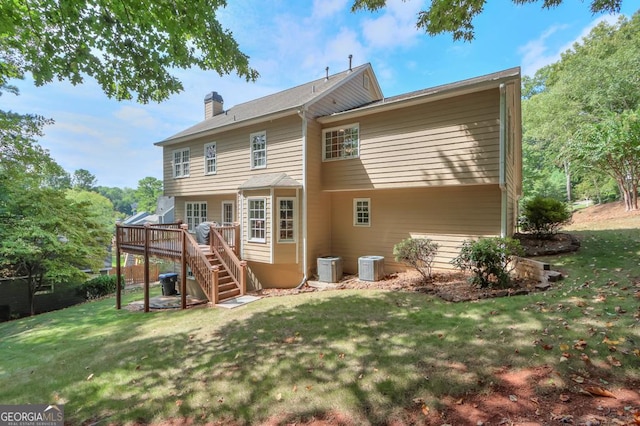 back of property with a deck, a yard, and cooling unit